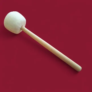 Un Martelletto / Batacchio Medio per campana tibetana e gong con una grande testa in feltro e un manico in legno è posizionato in diagonale su uno sfondo rosso uniforme.