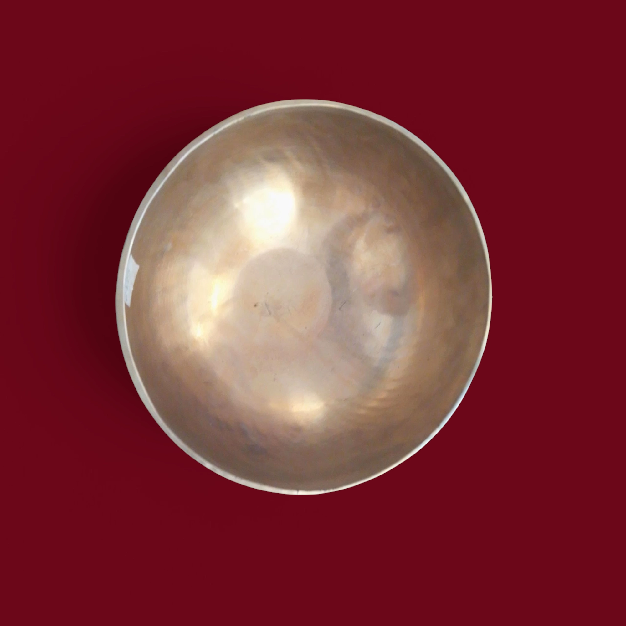 Una campana metallica Campana Tibetana Nota FA(F) d3 183 HZ -R125/C con finitura liscia, vista dall'alto su uno sfondo marrone, che risuona a 183 HZ (Nota FA).